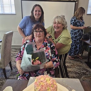 Women That Connect birthday celebration with cake and flowers