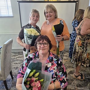 Women That Connect members receiving flowers at the anniversary meeting